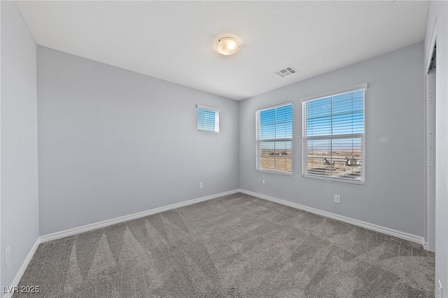 carpeted spare room with visible vents and baseboards