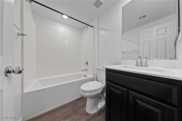 bathroom featuring toilet, visible vents, wood finished floors, and vanity