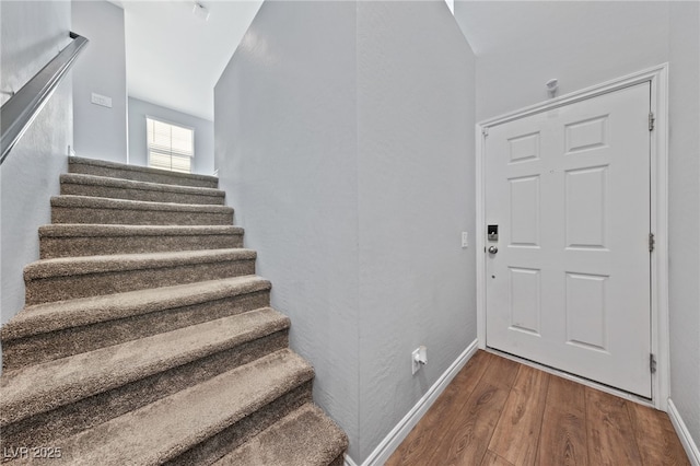 stairs with baseboards and wood finished floors