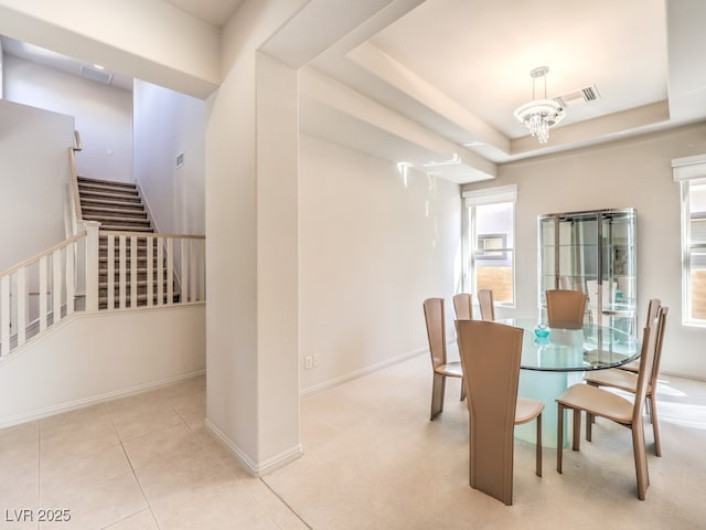 dining room with baseboards, stairs, tile patterned floors, a tray ceiling, and an inviting chandelier