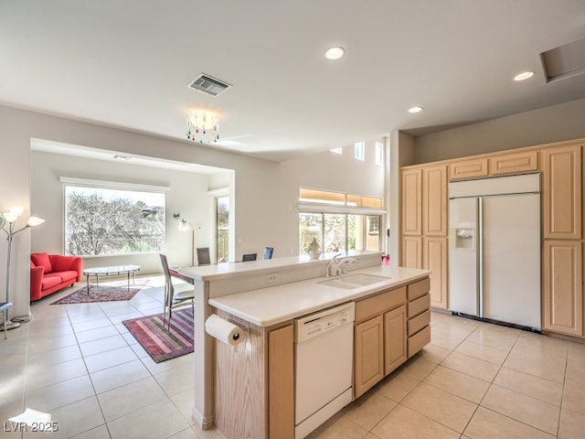 kitchen with visible vents, dishwasher, light brown cabinets, a sink, and built in fridge