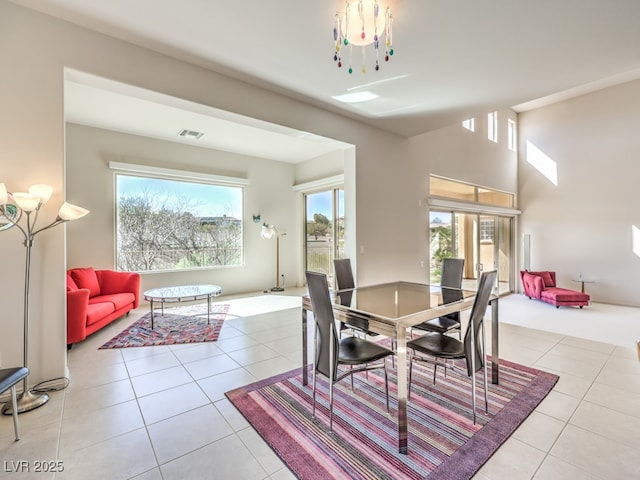 tiled dining space featuring a wealth of natural light and visible vents