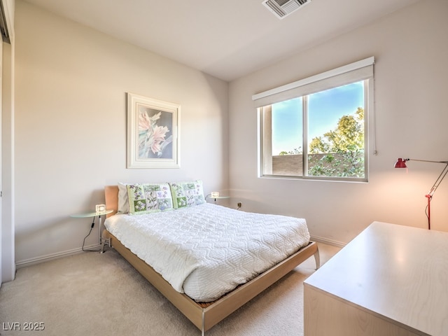 bedroom with baseboards, visible vents, and light colored carpet