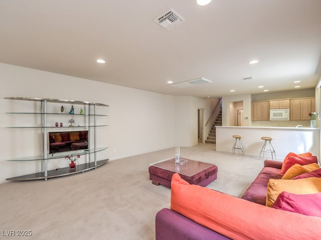 living area featuring recessed lighting, light colored carpet, visible vents, and stairs