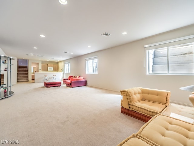 living area with light carpet, stairs, visible vents, and recessed lighting