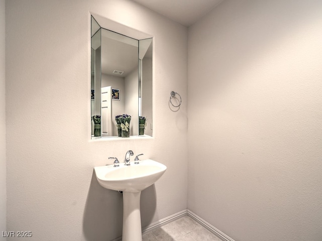 bathroom with baseboards and tile patterned flooring