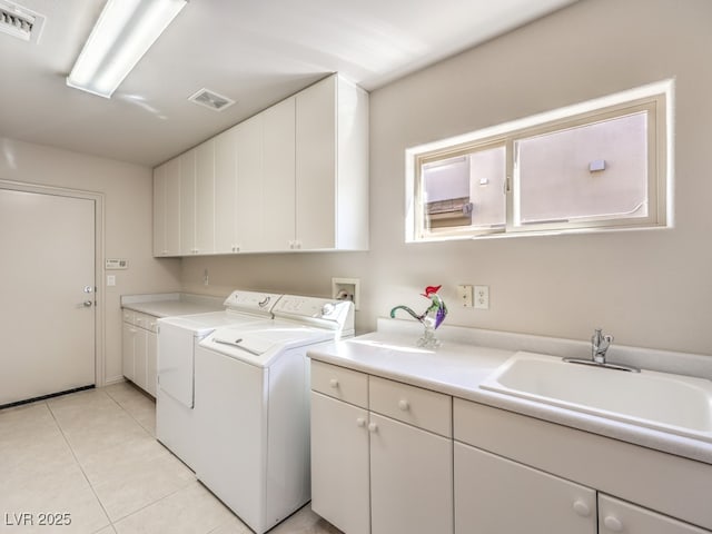 clothes washing area featuring visible vents, light tile patterned flooring, a sink, washing machine and dryer, and cabinet space