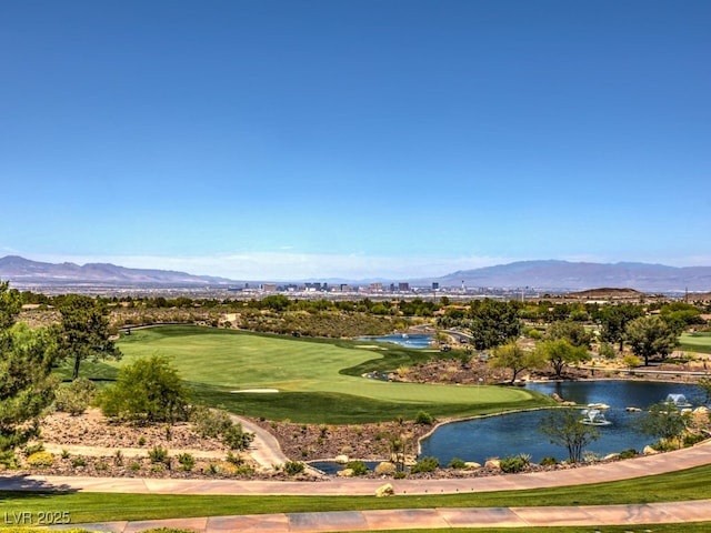 view of home's community featuring a mountain view, view of golf course, and a lawn