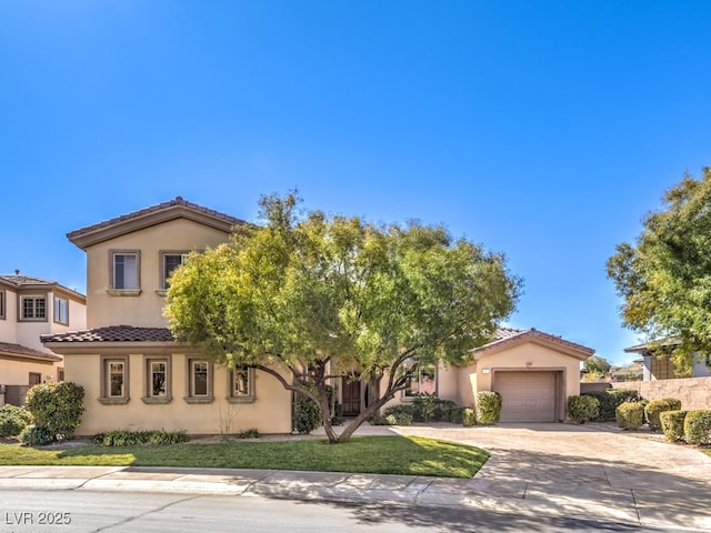 mediterranean / spanish home featuring concrete driveway, a tile roof, a garage, and stucco siding