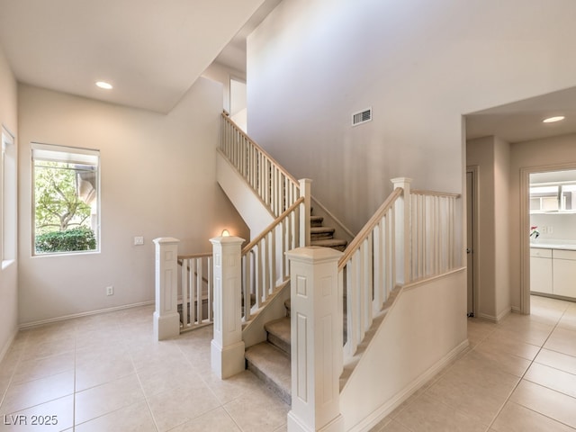stairway with baseboards, tile patterned flooring, visible vents, and recessed lighting