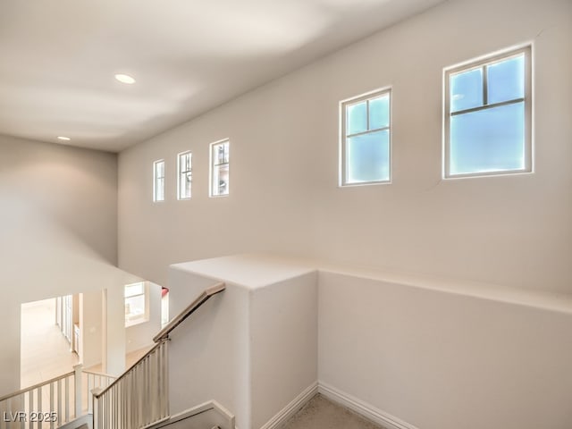 hallway with recessed lighting, an upstairs landing, and baseboards