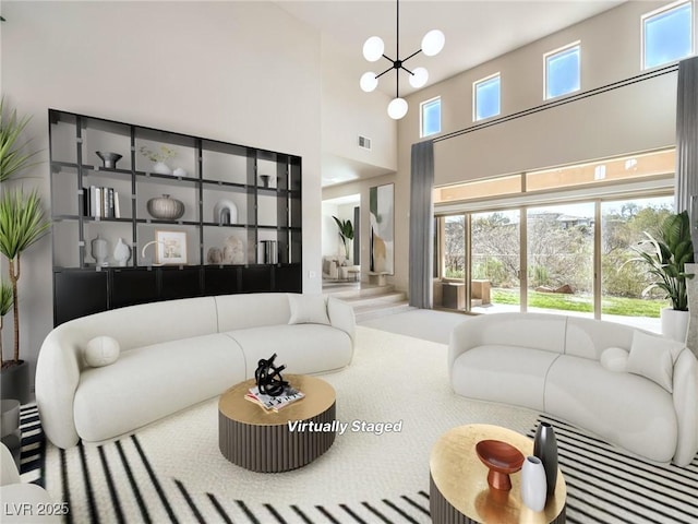 living area with an inviting chandelier, a towering ceiling, and visible vents