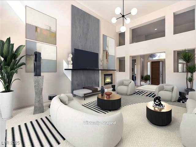 carpeted living area featuring a chandelier, a towering ceiling, and a fireplace