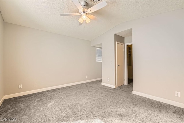 unfurnished bedroom featuring carpet, vaulted ceiling, a textured ceiling, and baseboards