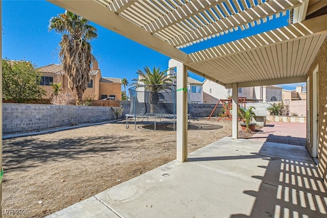 view of patio / terrace with a trampoline, fence, a pergola, and playground community