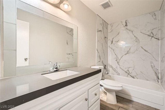 full bath featuring visible vents, a textured wall, toilet, wood finished floors, and vanity