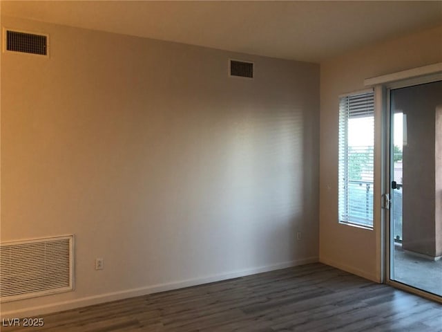 spare room featuring visible vents and dark wood-type flooring