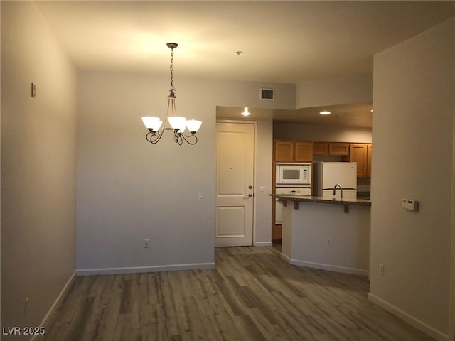 interior space with baseboards, visible vents, and wood finished floors