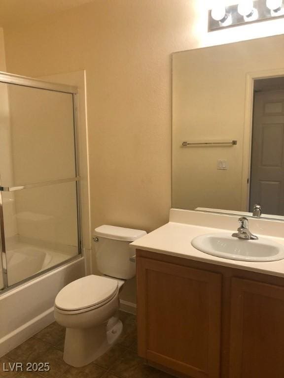 full bath with tile patterned flooring, vanity, toilet, and bath / shower combo with glass door