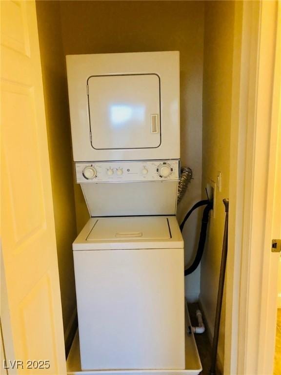 washroom with laundry area and stacked washer / drying machine