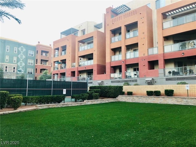 view of home's community with fence and a yard