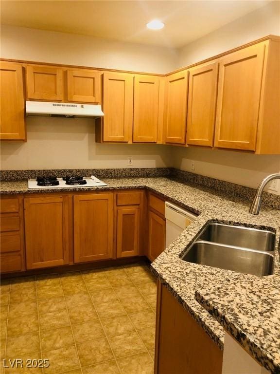 kitchen with recessed lighting, a sink, dark stone counters, white appliances, and under cabinet range hood