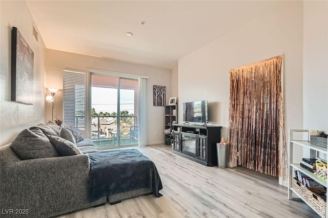 living area with visible vents, baseboards, and wood finished floors