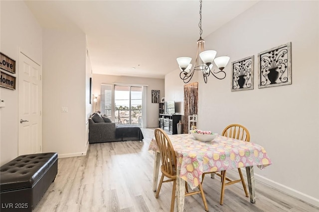 dining room featuring baseboards, an inviting chandelier, and light wood-style floors