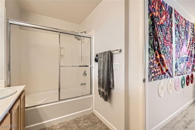 bathroom with baseboards, combined bath / shower with glass door, tile patterned flooring, and vanity