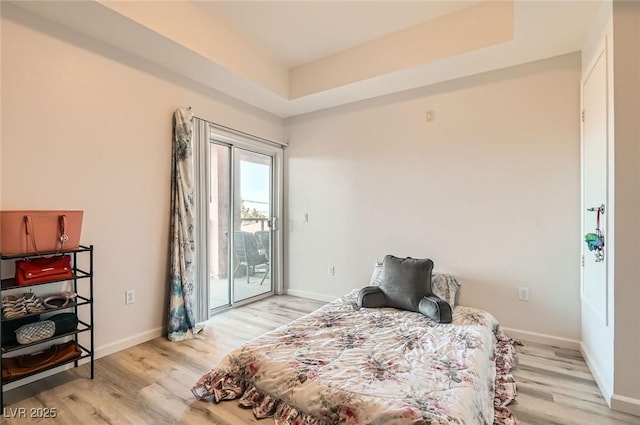 bedroom featuring baseboards, access to exterior, and light wood-style flooring