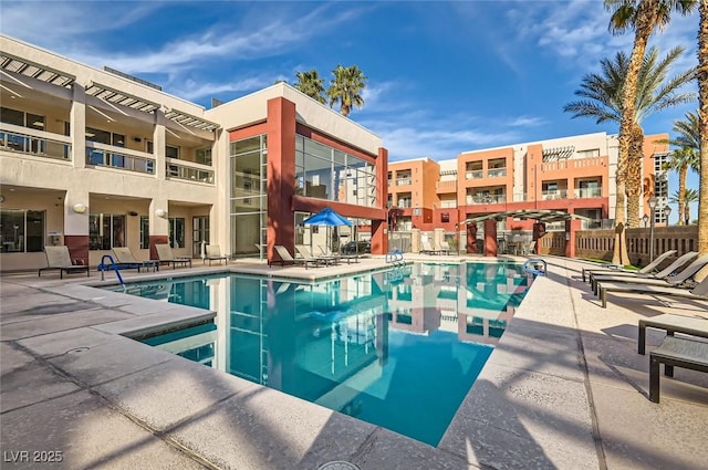 community pool with fence and a patio