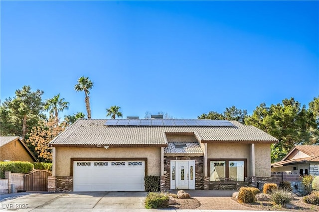 view of front of property with a garage, a gate, a tile roof, and concrete driveway