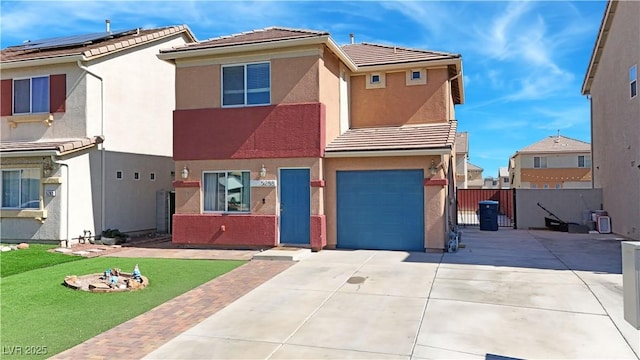 view of front of house with concrete driveway, a tile roof, an attached garage, fence, and stucco siding