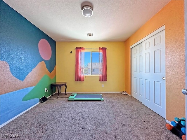 workout room with baseboards, a textured ceiling, visible vents, and carpet flooring