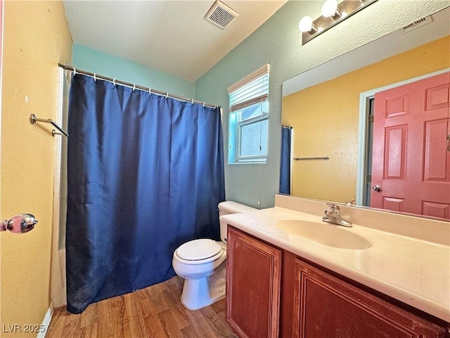 full bath with visible vents, vanity, toilet, and wood finished floors