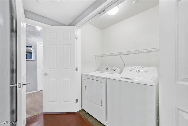 washroom featuring laundry area, washing machine and dryer, and dark wood-type flooring