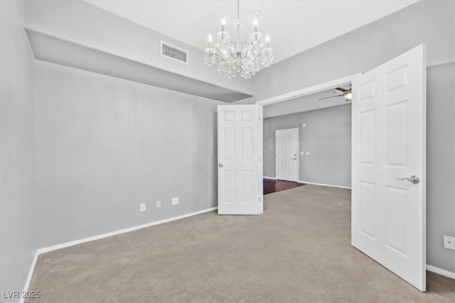 carpeted empty room featuring baseboards, visible vents, and ceiling fan with notable chandelier