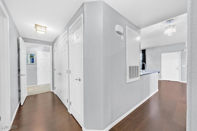 hallway featuring baseboards and dark wood-style flooring