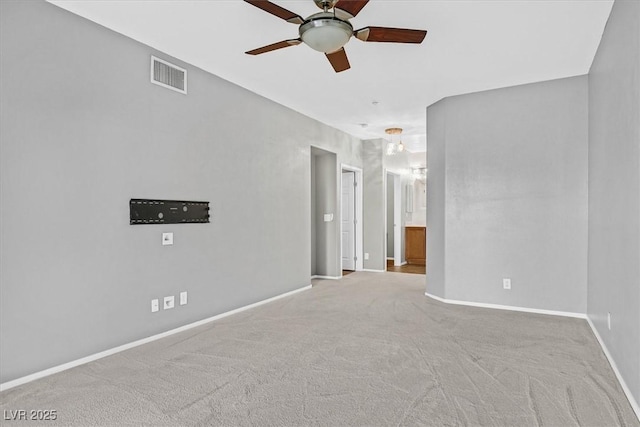 carpeted spare room featuring visible vents, ceiling fan, and baseboards