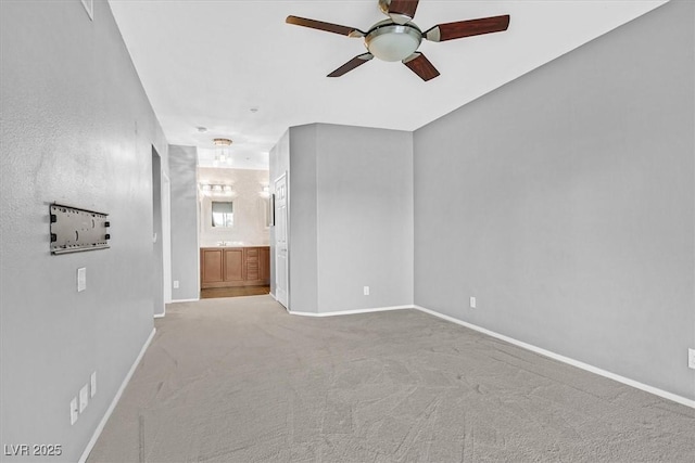 carpeted empty room with ceiling fan and baseboards