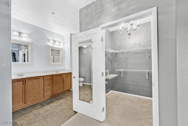 full bath featuring a sink, a spacious closet, toilet, and double vanity