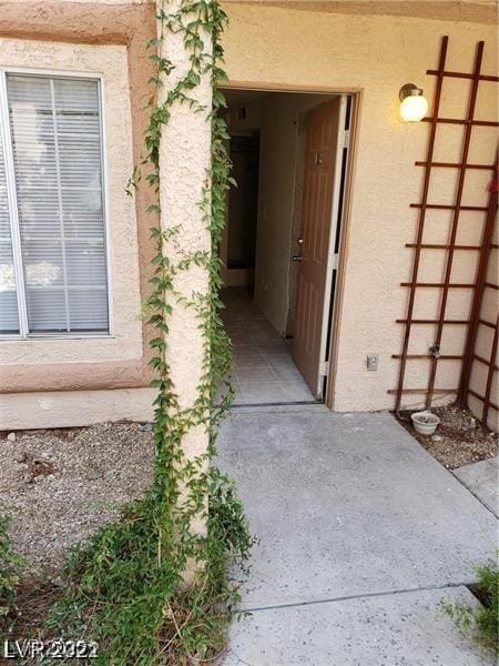 doorway to property featuring stucco siding