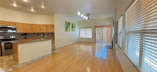 kitchen with light wood finished floors, tasteful backsplash, visible vents, appliances with stainless steel finishes, and dark stone counters