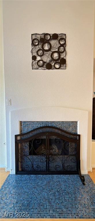 interior details with a fireplace with flush hearth and baseboards