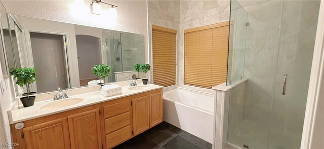 full bath featuring a sink, a bath, tile patterned floors, double vanity, and a stall shower