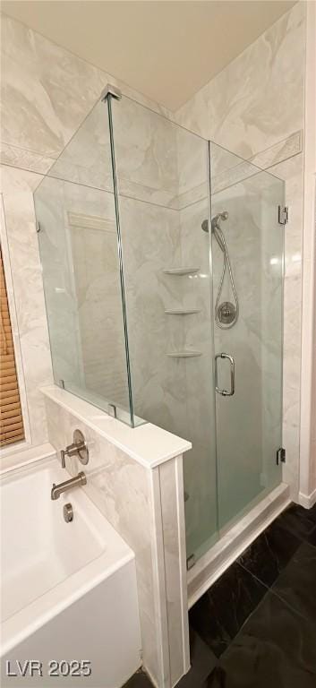 bathroom featuring a garden tub and a shower stall