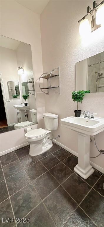 bathroom with toilet, baseboards, walk in shower, and tile patterned floors