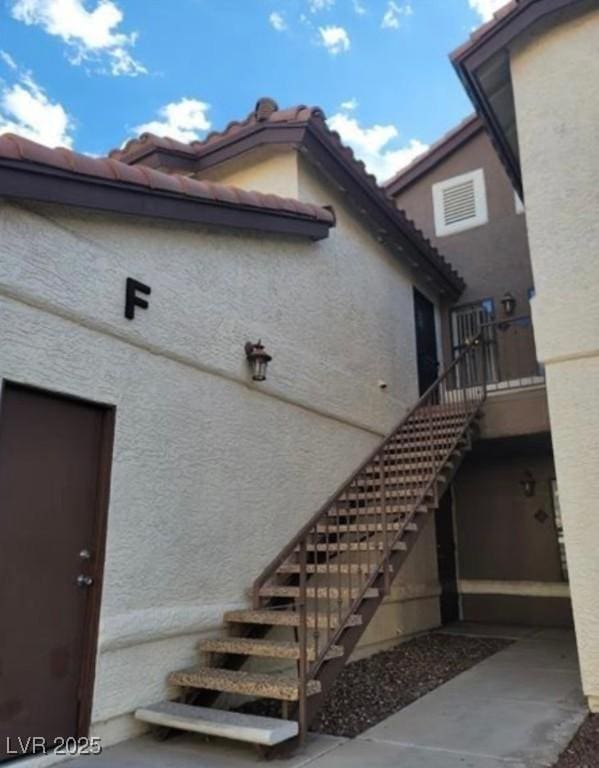 exterior space with stairs and stucco siding