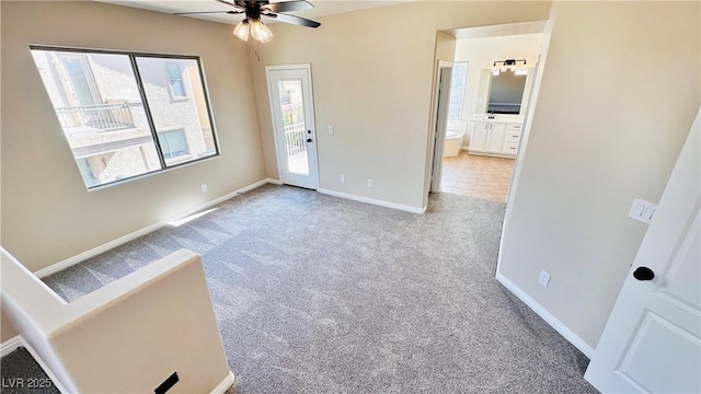 spare room with carpet floors, baseboards, and a ceiling fan