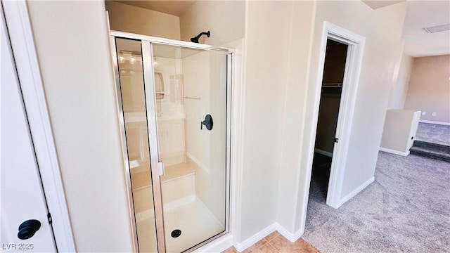 bathroom featuring a shower stall, visible vents, baseboards, and a walk in closet